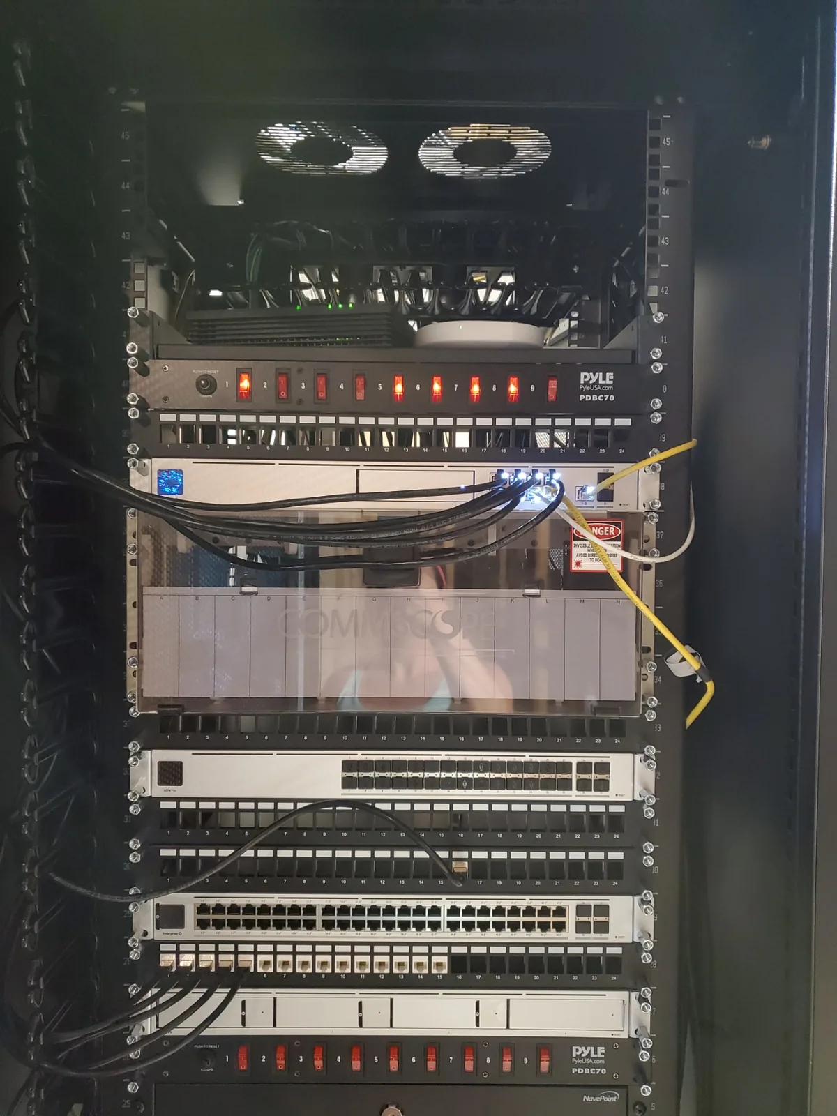 A full network rack: patch panels, switches, fiber and rack-mounted power distribution, cabled and running.
